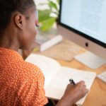 woman writing on her notebook