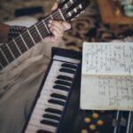 person playing guitar with musical notes